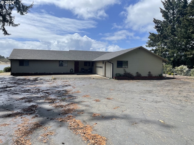 ranch-style home featuring aphalt driveway and an attached garage