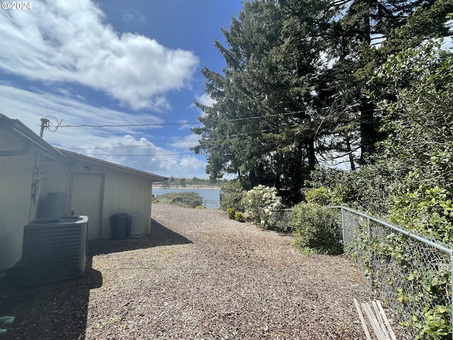 view of yard with central air condition unit and fence