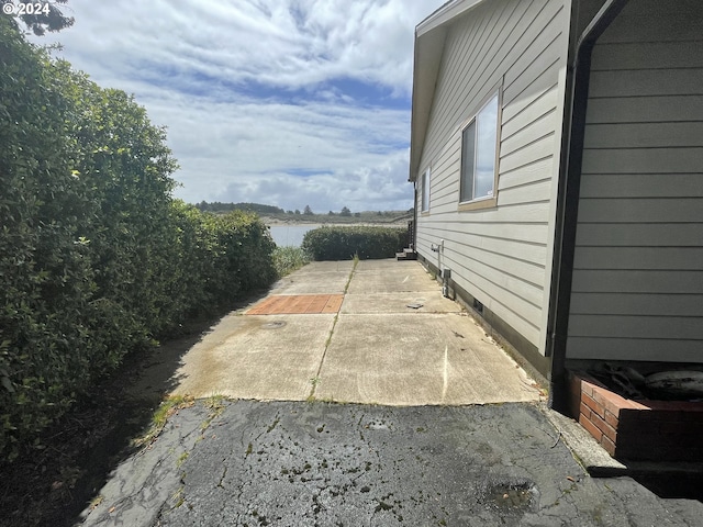 view of side of home featuring a water view and a patio