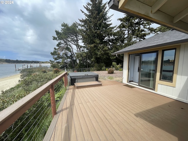 wooden deck featuring a water view and hot tub deck surround