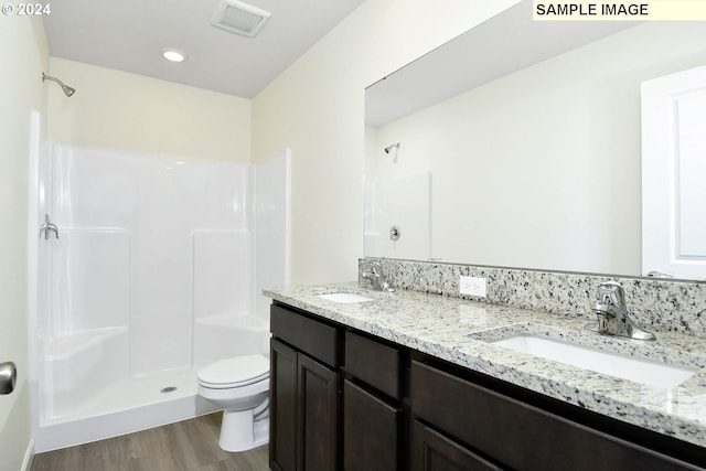 bathroom with toilet, a shower, wood-type flooring, and vanity