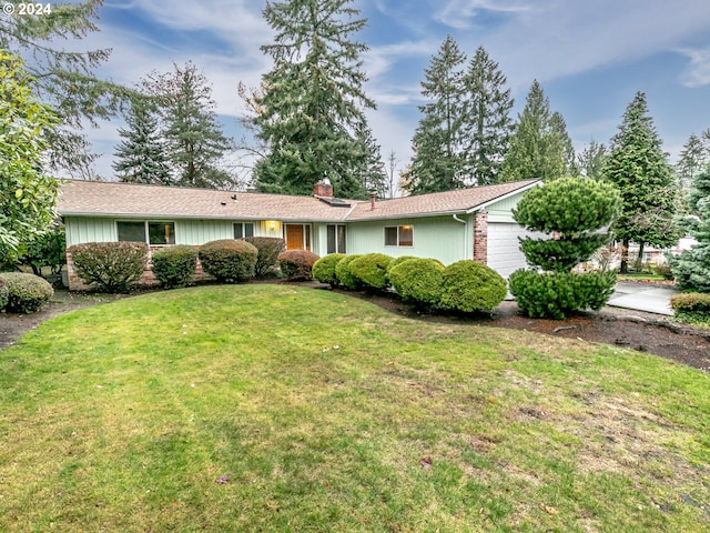 single story home featuring a garage and a front lawn