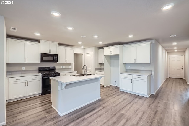 kitchen featuring black appliances, light hardwood / wood-style floors, white cabinetry, and sink