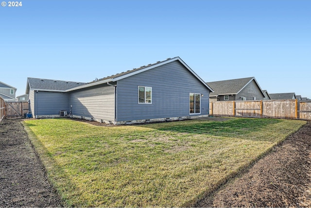 rear view of house with a lawn and cooling unit