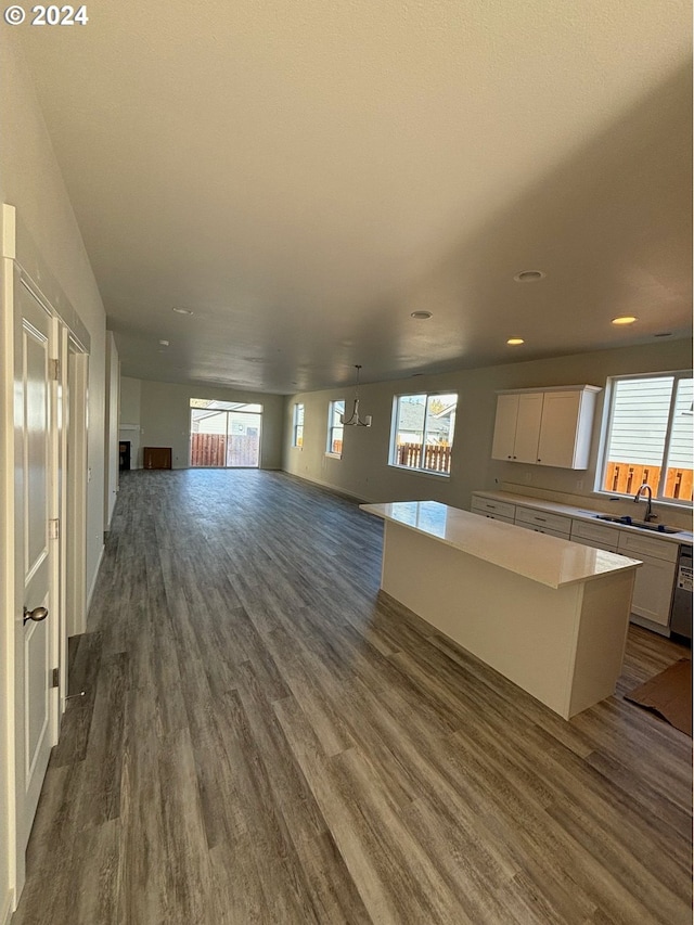 unfurnished living room featuring dark wood-type flooring, a healthy amount of sunlight, and sink