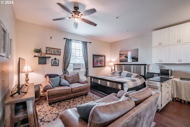 bedroom featuring cooling unit, dark hardwood / wood-style floors, and ceiling fan