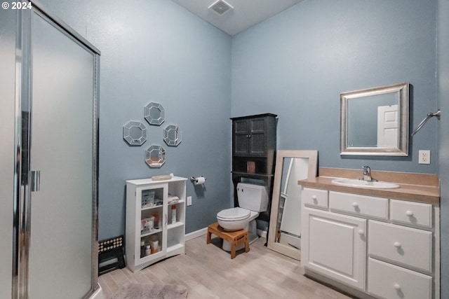 bathroom with vanity, hardwood / wood-style floors, toilet, and an enclosed shower