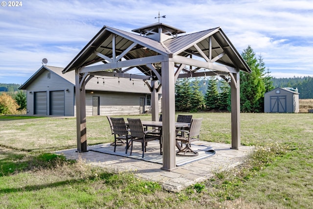 view of patio featuring a shed and a garage