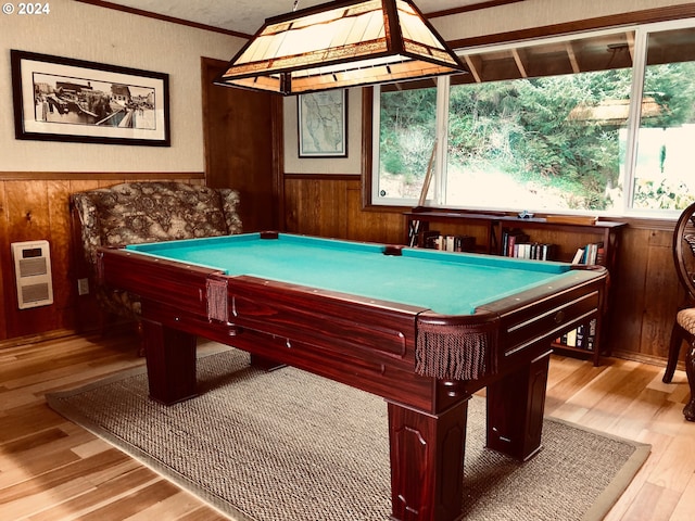 recreation room featuring ornamental molding, light hardwood / wood-style floors, heating unit, and wood walls