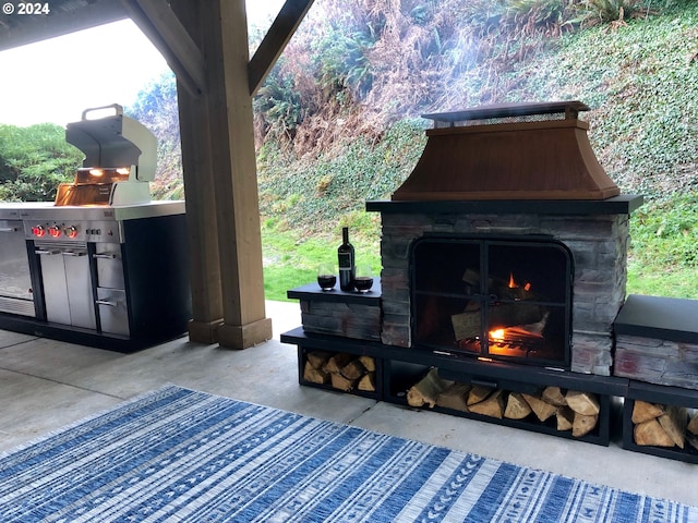 view of patio / terrace featuring area for grilling and an outdoor stone fireplace