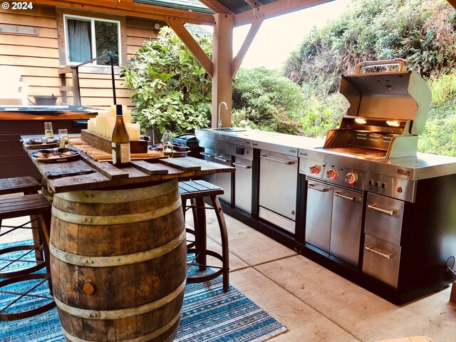 view of patio / terrace featuring area for grilling and an outdoor stone fireplace