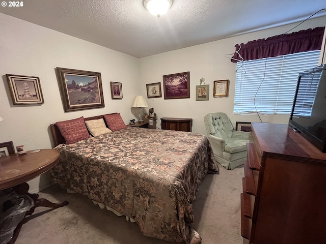 bedroom with light carpet and a textured ceiling