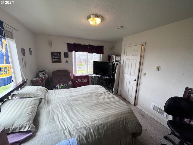 bedroom featuring a textured ceiling and carpet flooring