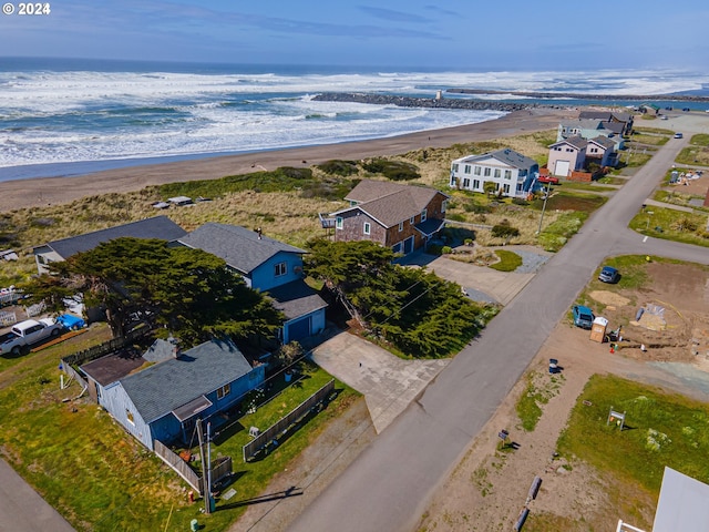 birds eye view of property with a water view and a beach view