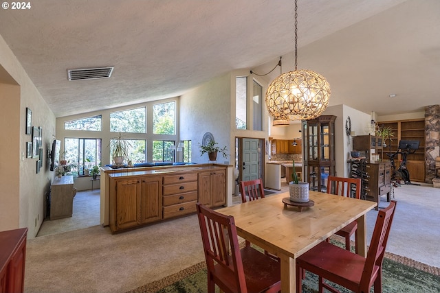 dining room with a textured ceiling, high vaulted ceiling, light carpet, visible vents, and an inviting chandelier