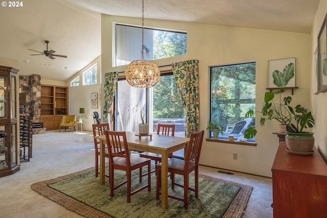 dining room with high vaulted ceiling, a healthy amount of sunlight, and carpet flooring