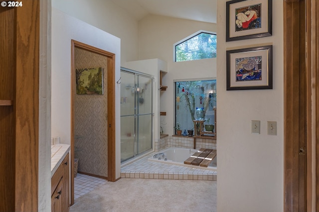 full bathroom featuring a stall shower, lofted ceiling, vanity, and a bath