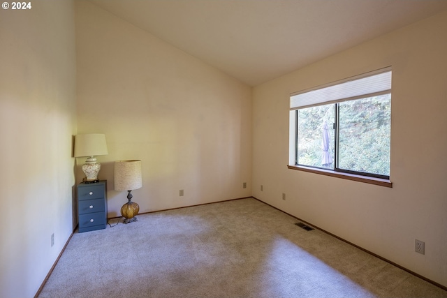 unfurnished room featuring vaulted ceiling, carpet floors, visible vents, and baseboards