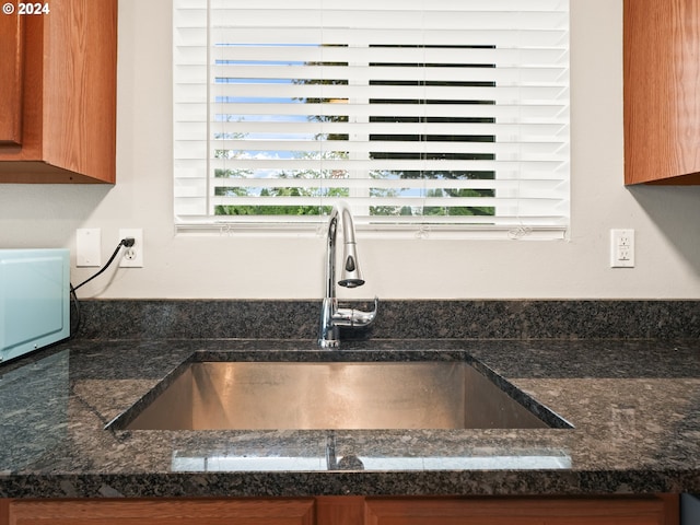 interior details featuring sink and dark stone counters