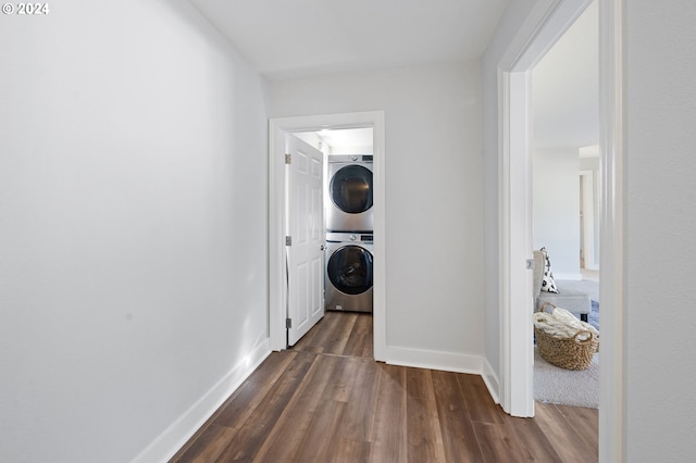 clothes washing area with stacked washer and clothes dryer and dark hardwood / wood-style flooring