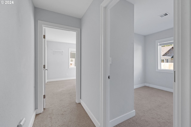 hall with light colored carpet