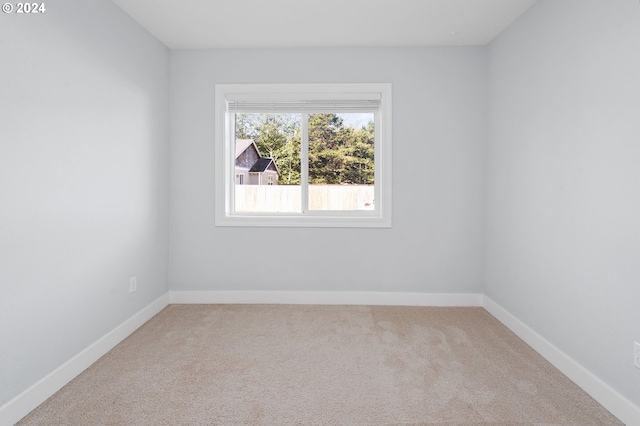 unfurnished room featuring light carpet