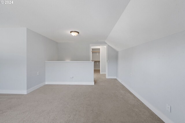 additional living space with lofted ceiling and light colored carpet