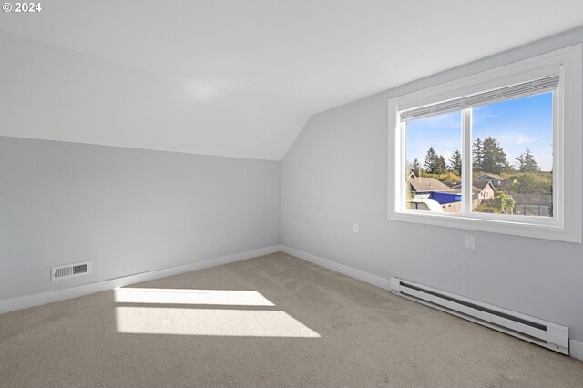 bonus room featuring light colored carpet, vaulted ceiling, and a baseboard heating unit