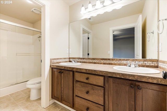 bathroom featuring vanity, tile patterned floors, decorative backsplash, toilet, and walk in shower