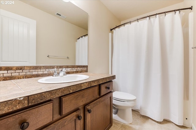 bathroom with tile patterned flooring, vanity, and toilet