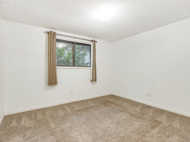 carpeted spare room with a textured ceiling