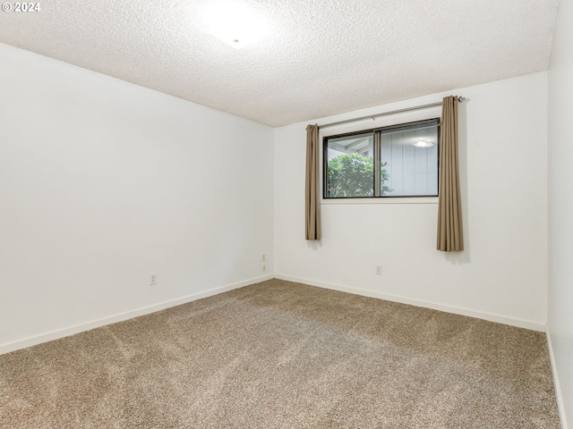 carpeted empty room with a textured ceiling