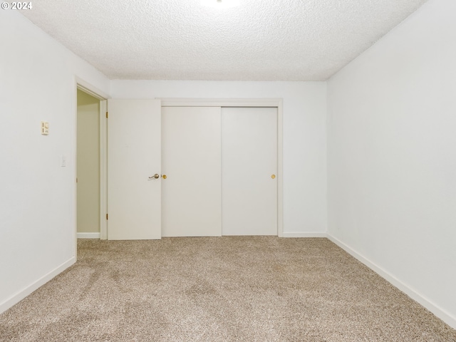 unfurnished bedroom featuring a closet, carpet, and a textured ceiling