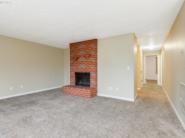 unfurnished living room featuring a textured ceiling, light carpet, and a brick fireplace