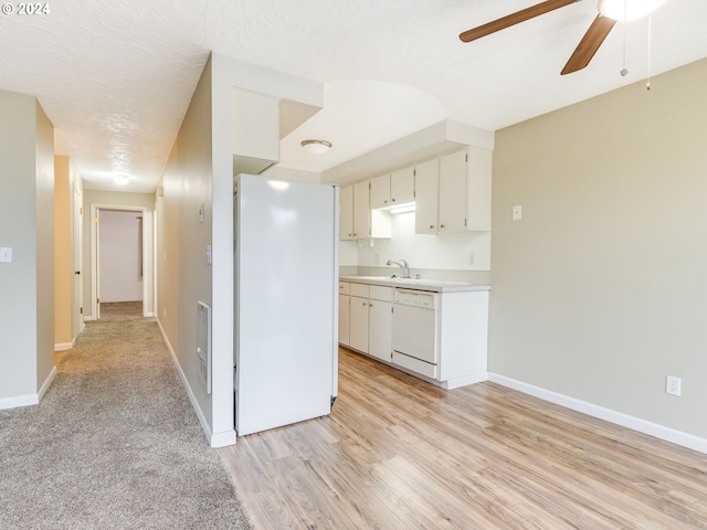 kitchen featuring white appliances, light hardwood / wood-style floors, white cabinetry, and ceiling fan