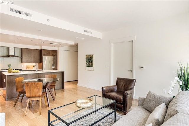 living room with sink and light hardwood / wood-style flooring