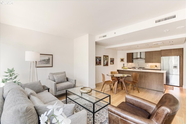 living room with sink and light hardwood / wood-style flooring