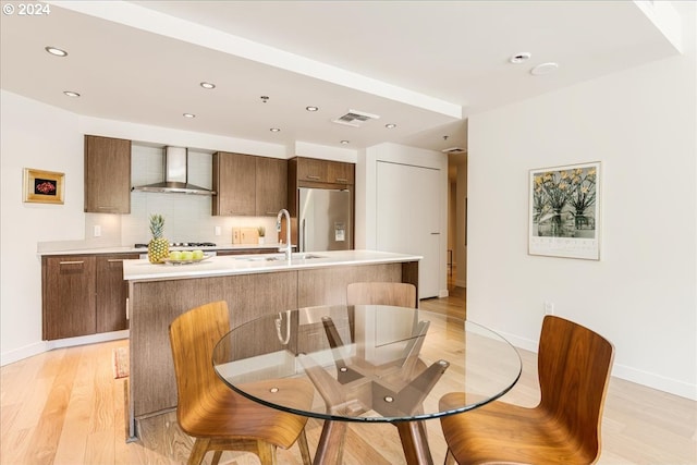 dining space with light wood-type flooring and sink