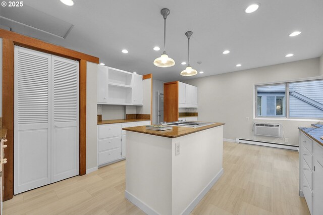 kitchen with white cabinets, a wall mounted AC, a baseboard radiator, and pendant lighting