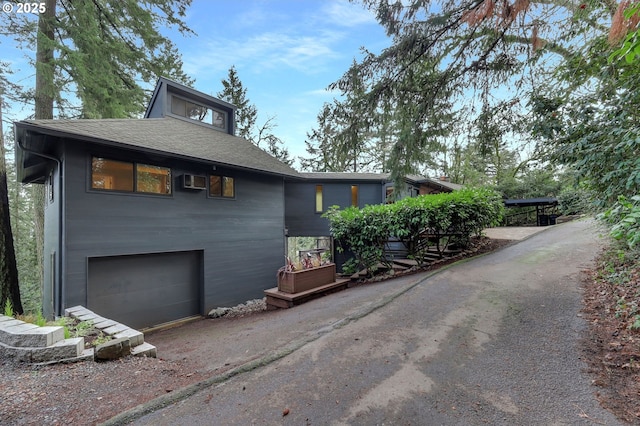 view of side of property with an AC wall unit and a garage