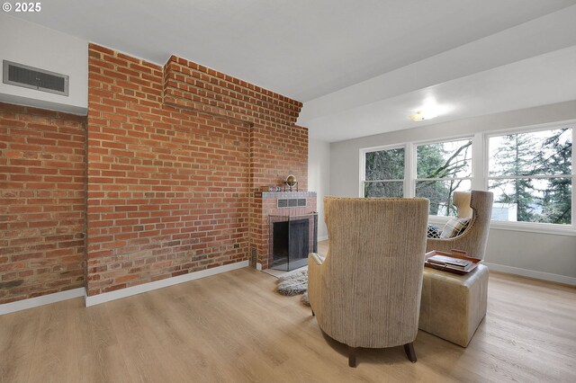 unfurnished bedroom with brick wall and light hardwood / wood-style floors