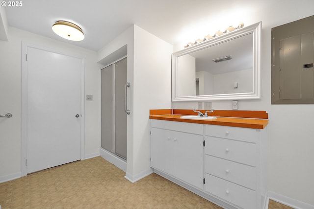 bathroom featuring electric panel, walk in shower, and vanity