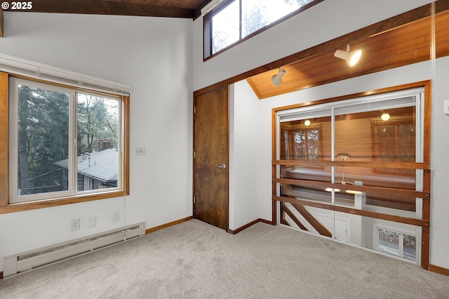 spare room featuring carpet flooring, baseboard heating, high vaulted ceiling, and wood ceiling