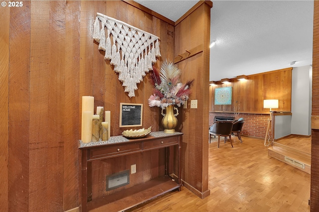 hall featuring hardwood / wood-style flooring, brick wall, and wood walls