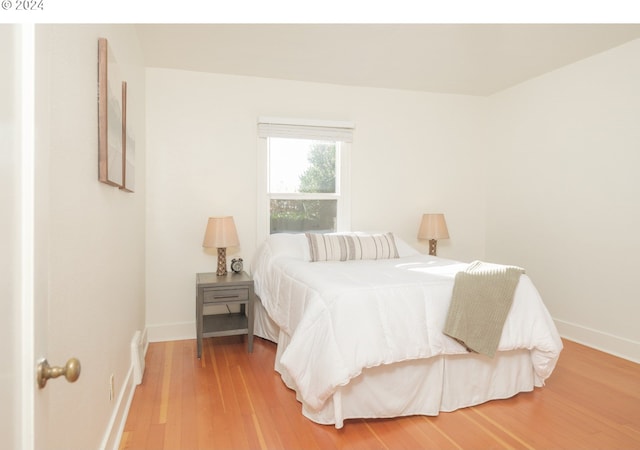 bedroom featuring light wood-style floors and baseboards