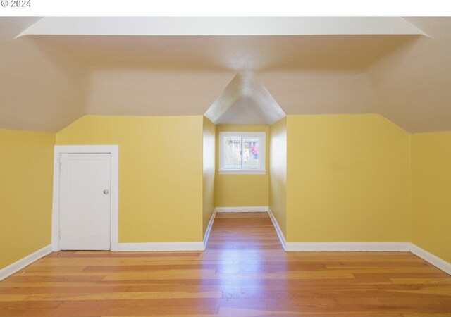 bonus room with hardwood / wood-style floors and lofted ceiling