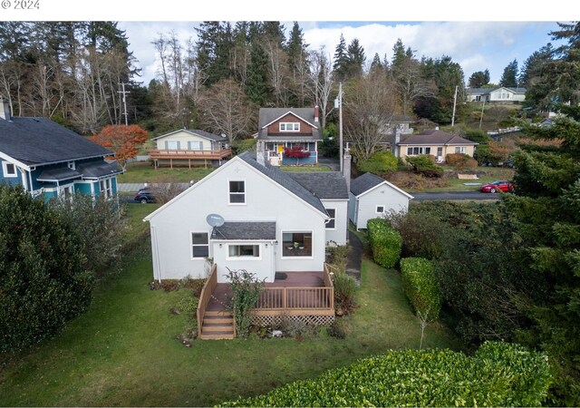 rear view of house featuring a lawn and a deck