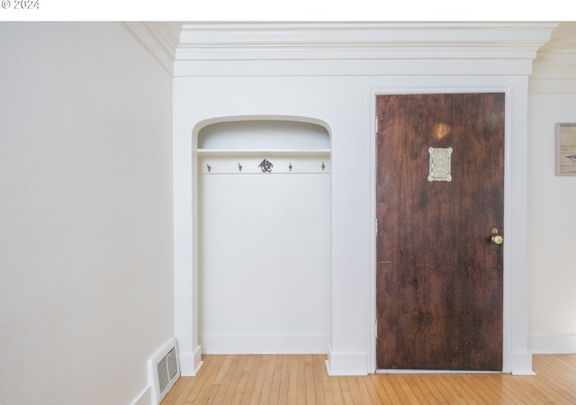 mudroom with baseboards, light wood-style flooring, and visible vents
