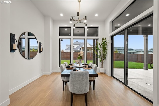 dining area featuring an inviting chandelier and light hardwood / wood-style flooring