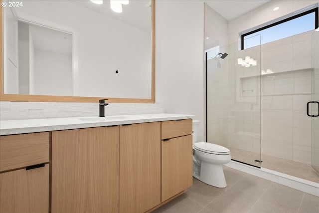 bathroom featuring toilet, tile patterned flooring, a shower with shower door, and vanity